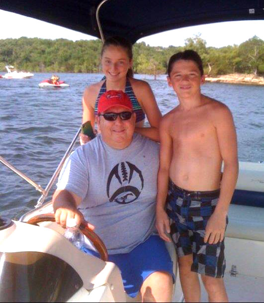 Bob boating with his kids on the lake