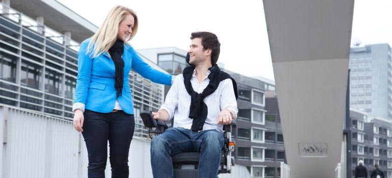 A man using a power wheelchair with his girlfriend