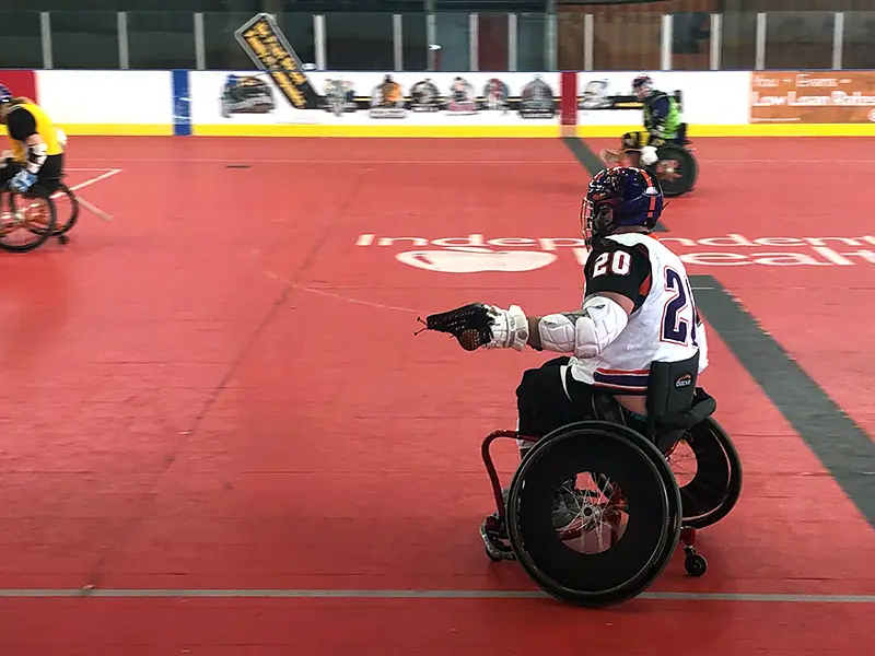 Wheelchair lacrosse player moving with the ball