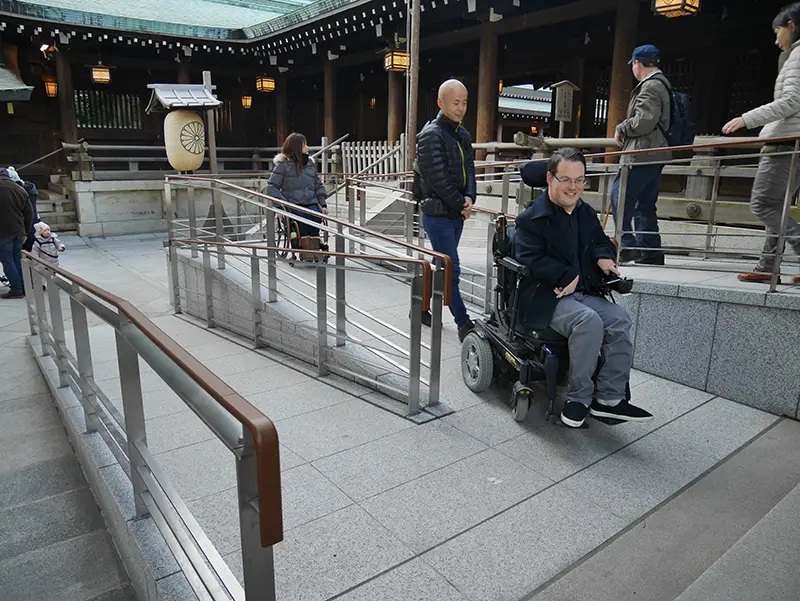 A person using a power wheelchair using an accessible ramp in Japan