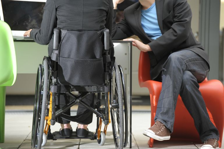 A person who uses a wheelchair working with an able-bodied colleague