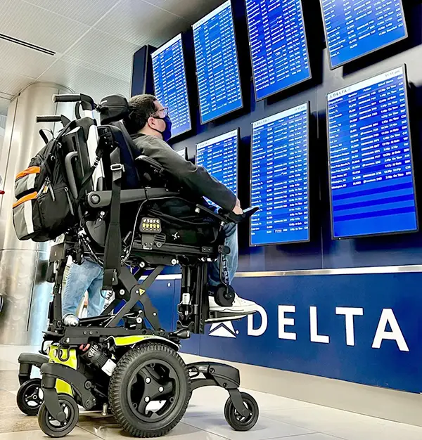 Cory using power seat elevate to see departure times at an airport